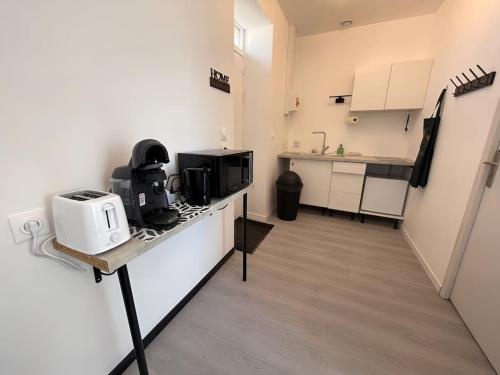 une petite cuisine avec un comptoir et un four micro-ondes dans l'établissement Studio B2 20m2 cosy 5min à pied des Gares, à Roanne