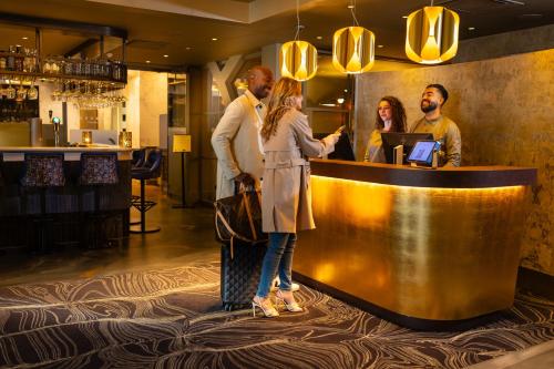 a group of people standing at a bar in a restaurant at Boutique Hotel Albus Amsterdam Centre in Amsterdam
