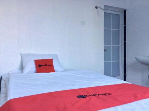 a bed with a red book on top of it at Reddoorz Syariah near Sleman city hall 4 in Sleman