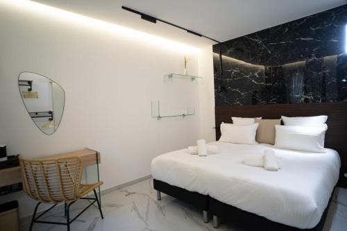 a bedroom with a large white bed and a chair at La Villa Ora in Antibes
