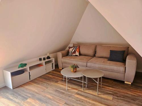 ein Wohnzimmer mit Couch und Tisch in der Unterkunft Dachnest mit Terasse & Sauna in Oerlinghausen