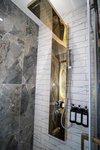 a bathroom with a shower with a stone wall at La Villa Ora in Antibes