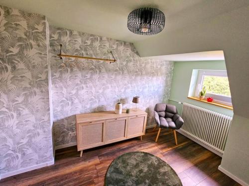 a living room with a desk and a chair at Dachnest mit Terasse & Sauna in Oerlinghausen