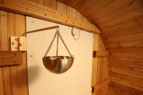 a metal bowl hanging from a wall in a cabin at 那須町湯本の那須御用邸近くのログハウス in Nasu-yumoto