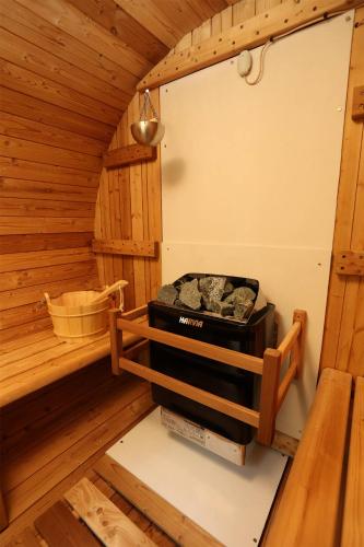an inside view of a sauna with a stove at 那須町湯本の那須御用邸近くのログハウス in Nasu-yumoto