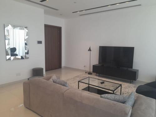 a living room with a couch and a flat screen tv at 360 Building - City View 2 Bedroom Residence in Nicosia