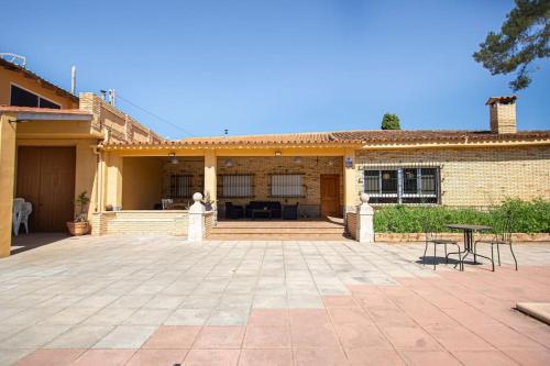 a patio in front of a brick building with a table at Villa con piscina y barbacoa para 13 personas cerca del metro in Valencia