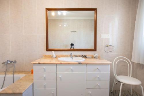 a bathroom with a sink and a mirror and a tub at Villa con piscina y barbacoa para 13 personas cerca del metro in Valencia