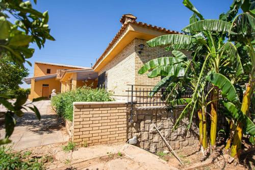 a house with a brick fence in front of it at Villa con piscina y barbacoa para 13 personas cerca del metro in Valencia
