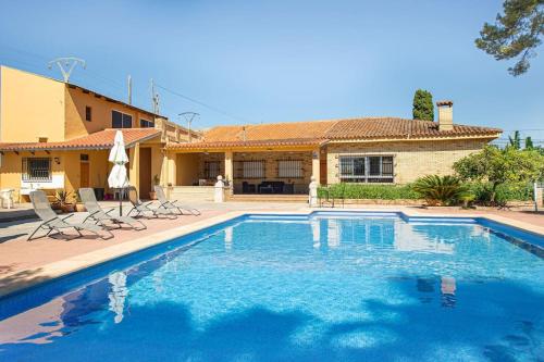 a swimming pool in front of a house at Villa con piscina y barbacoa para 13 personas cerca del metro in Valencia