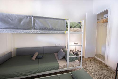 a bedroom with two bunk beds in a room at Villa con piscina y barbacoa para 13 personas cerca del metro in Valencia