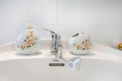a bathroom sink with two cups and a faucet at Villa con piscina y barbacoa para 13 personas cerca del metro in Valencia