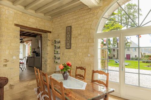 une salle à manger avec une table et des chaises et une fenêtre dans l'établissement manoir de vauville, à Fresville