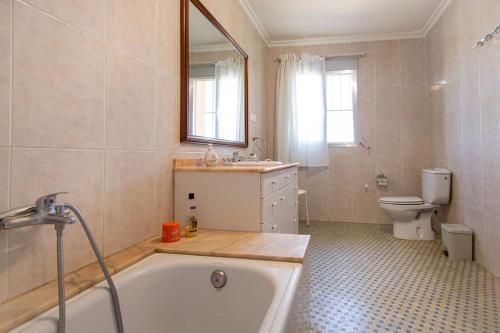 a bathroom with a bath tub and a toilet at Villa con piscina y barbacoa para 13 personas cerca del metro in Valencia