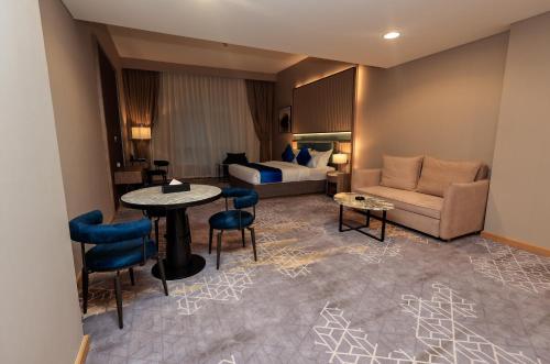 a hotel room with a bed and a table and chairs at Best Western Premier M Four Hotel in Dubai