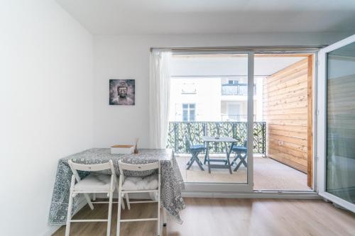 une salle à manger avec une table et des chaises et un balcon dans l'établissement Le Montfleury - Appt poche de Paris, à Sarcelles