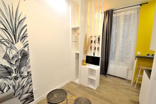 un salon avec une télévision et une chambre avec une fenêtre dans l'établissement Tiny cosy studio NAMASTAY in trendy Canal St Martin area, à Paris