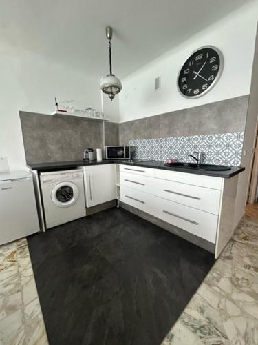 une cuisine avec un évier et une horloge murale dans l'établissement Studio avec Vue Imprenable sur la Mer, à Menton