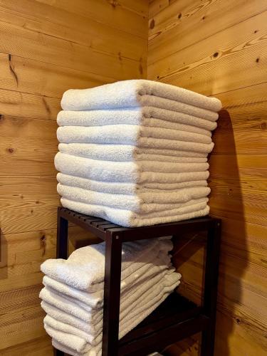 a stack of towels on a rack in a room at LOGIS HÔTEL, CHALETS et RESTAURANT LES CHATELMINÉS in La Bresse