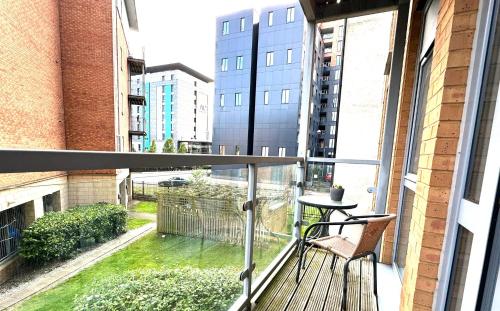 a balcony with a chair and a table on it at 2 Bed ensuite with Balcony and Free onsite Secure Parking in Manchester