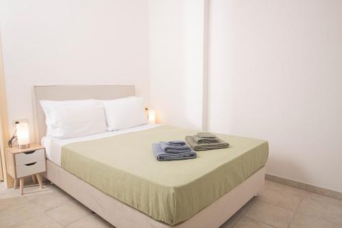 a bedroom with a bed with two towels on it at Kastoras Apartments in Kardamili