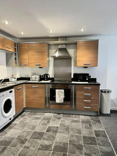 a kitchen with a stove and a dishwasher at 2 Bed ensuite with Balcony and Free onsite Secure Parking in Manchester