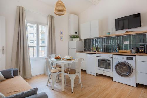 une cuisine et un salon avec une table et des chaises dans l'établissement La Corderie - Sous les toits de Marseille, à Marseille