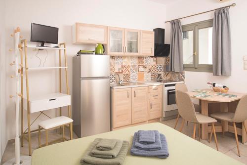 a kitchen with a refrigerator and a table with chairs at Kastoras Apartments in Kardamili