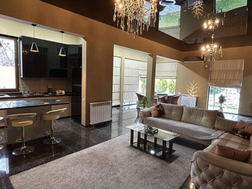 a living room with a couch and a kitchen at Green Land in Tbilisi City