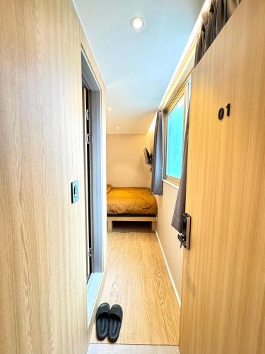 a small room with a bed in a tiny house at Well Plus Guest House in Seoul