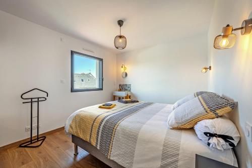 a bedroom with a large bed with a window at Ti Braz Magnifique Maison Piscine in Plouguerneau