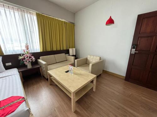 a living room with a couch and a table at Aloha Hatyai Hotel in Hat Yai
