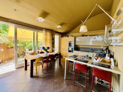 Una cocina y un comedor con mesa y sillas. en Serra Boutique Villa & Spa, en Ghiffa