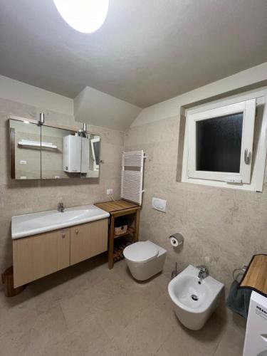 a bathroom with a toilet and a tub and a sink at Serra Boutique Villa & Spa in Ghiffa