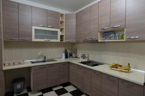 a kitchen with wooden cabinets and a bowl of fruit on the counter at Green Art House in Kovilovo
