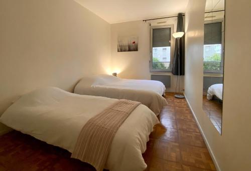 une chambre avec deux lits et une fenêtre dans l'établissement Appartement spacieux Paris Vanves Parc des expositions, à Vanves
