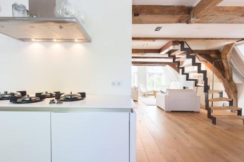 a white kitchen with a staircase in a loft at City Hotel Rembrandt in Leiden