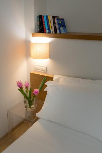 a bed with a vase of flowers on a table at Hotel Baltic in Giulianova