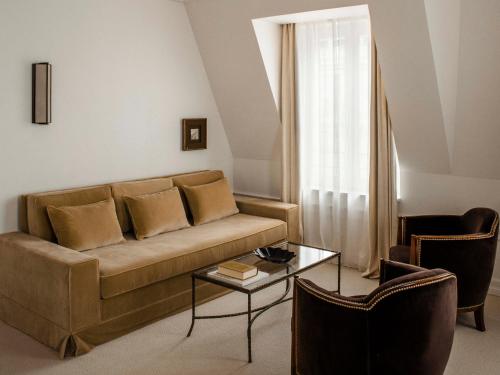 a living room with a couch and a table at Hôtel Balzac Paris & Spa Ikoï in Paris