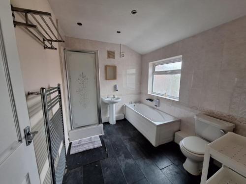 a bathroom with a tub and a toilet and a sink at Cinematic Journeys in Nottingham