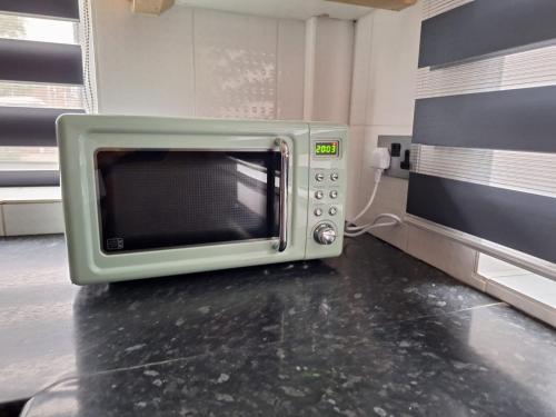 a microwave sitting on a counter in a kitchen at Cinematic Journeys in Nottingham