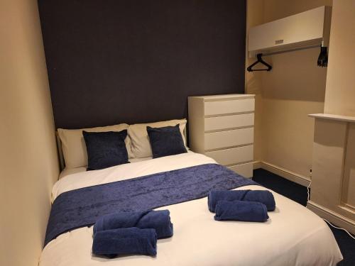 a bedroom with a large bed with blue towels on it at Cinematic Journeys in Nottingham