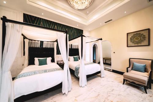 a bedroom with two beds and a chandelier at Mekong River Jing Land Hotel in Jinghong