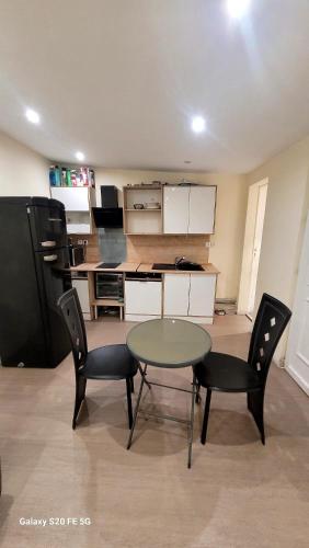 une pièce avec une table et des chaises et une cuisine dans l'établissement Maisonnette - Type F2, à Tremblay-en-France