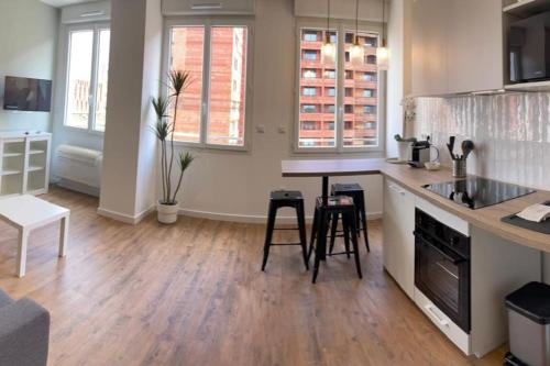 une cuisine avec un comptoir, une table et des chaises dans l'établissement Clim Ascenseur R4 T2 moderne au cœur de Toulouse, à Toulouse