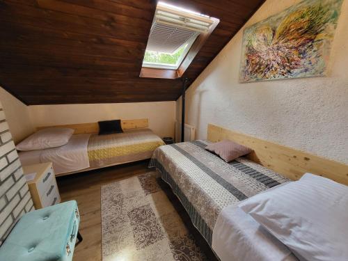 a bedroom with two beds and a skylight at Koča sredi gozda in Kanal