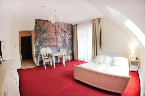 a bedroom with a bed and a table with chairs at Malutkie Resort in Radomsko