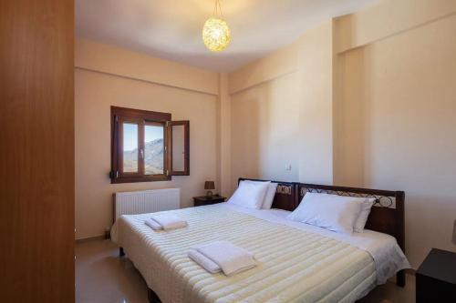 a bedroom with a bed with two towels on it at Camellia in Saktoúria