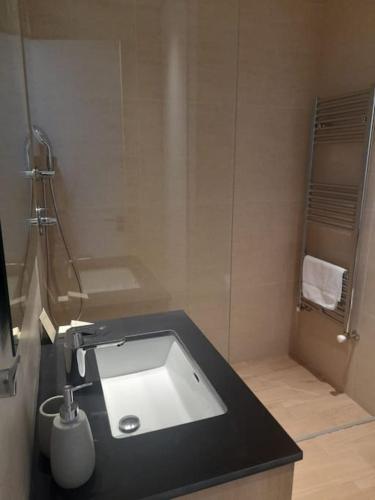 ein Badezimmer mit einem Waschbecken mit schwarzer Arbeitsplatte in der Unterkunft 360 Nicosia-2 Bedroom City Tower in Nikosia