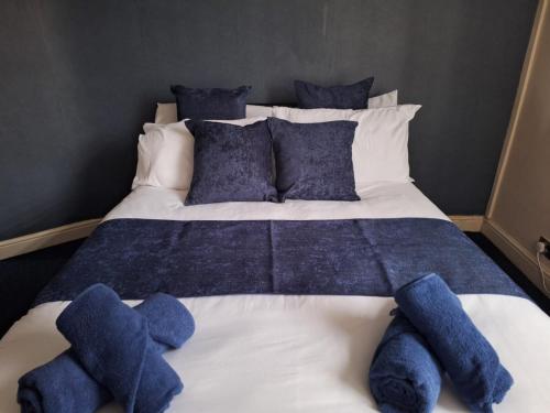 a large bed with blue stuffed animals on it at Cinematic Journeys in Nottingham